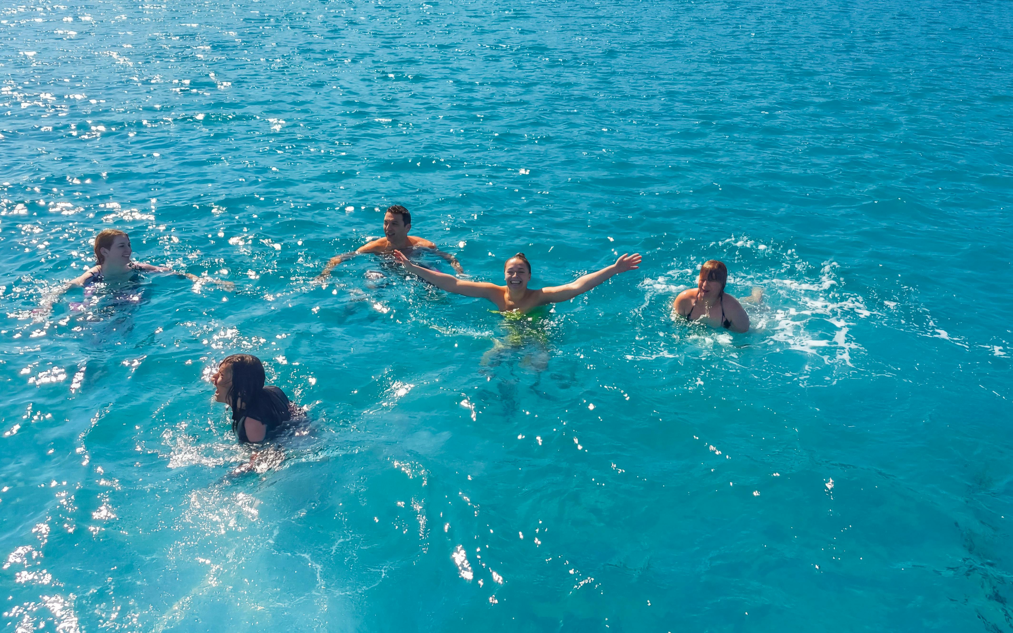 People swimming in the clear blue waters of the Mediterranean during a Blue Lagoon cruise from Latchi.