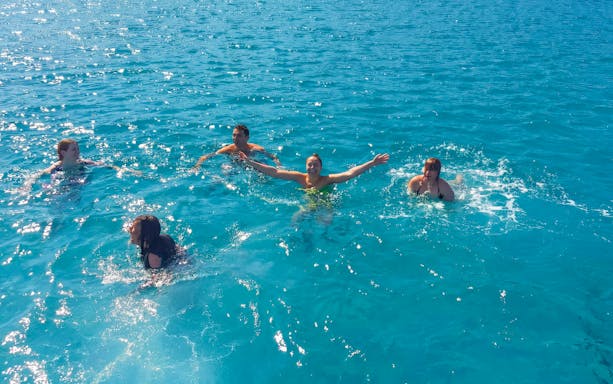 People swimming in the clear blue waters of the Mediterranean during a Blue Lagoon cruise from Latchi.