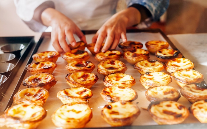 Pastéis de Nata being arranged on a tray during Lisbon & Belém Small Group Tour.
