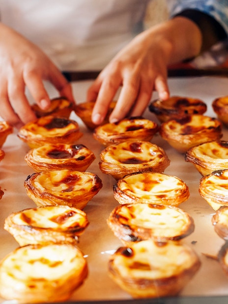 Pastéis de Nata being arranged on a tray during Lisbon & Belém Small Group Tour.
