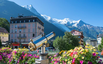 Telescope view of Chamonix Mont Blanc with colorful flowers and mountain backdrop.