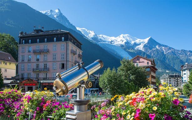 Telescope view of Chamonix Mont Blanc with colorful flowers and mountain backdrop.