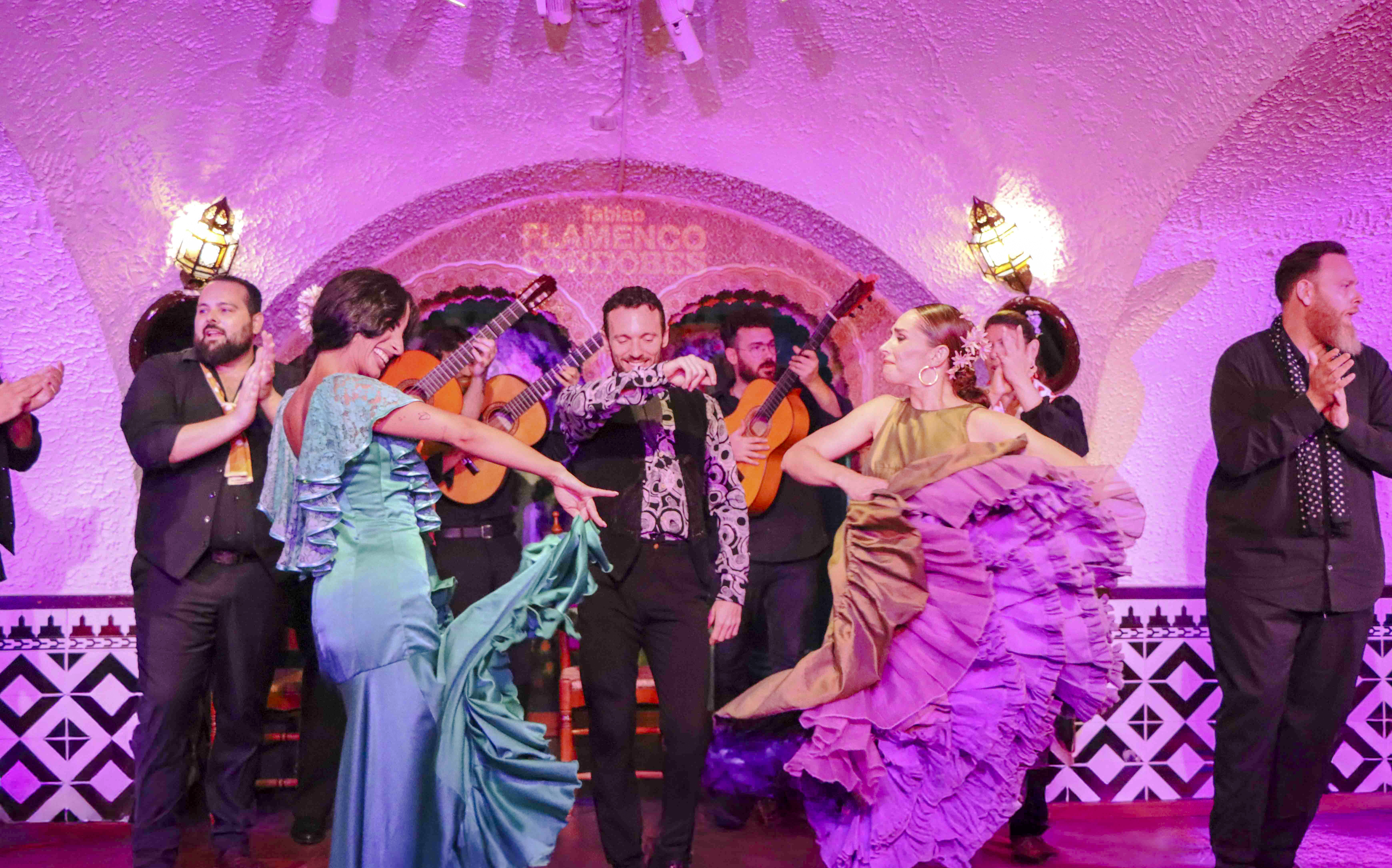 Flamenco dancers performing at Tablao Cordobes in vibrant costumes.
