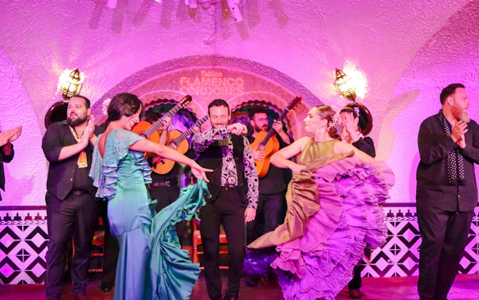 Flamenco dancers performing at Tablao Cordobes in vibrant costumes.