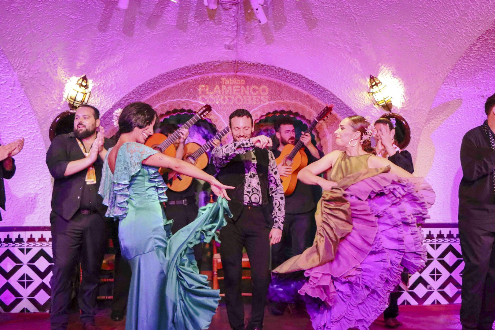 Flamenco dancers performing at Tablao Cordobes in vibrant costumes.