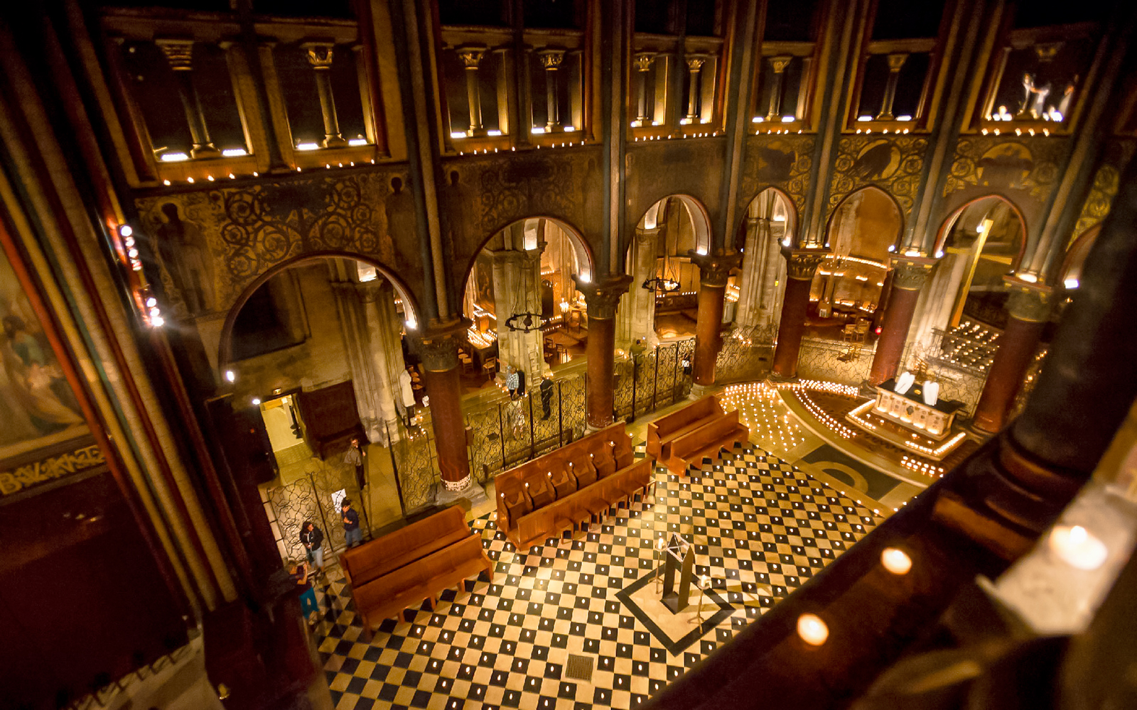 Orchestra setup in St Germain des Prés Church, Paris, with lit candles and ornate architecture.