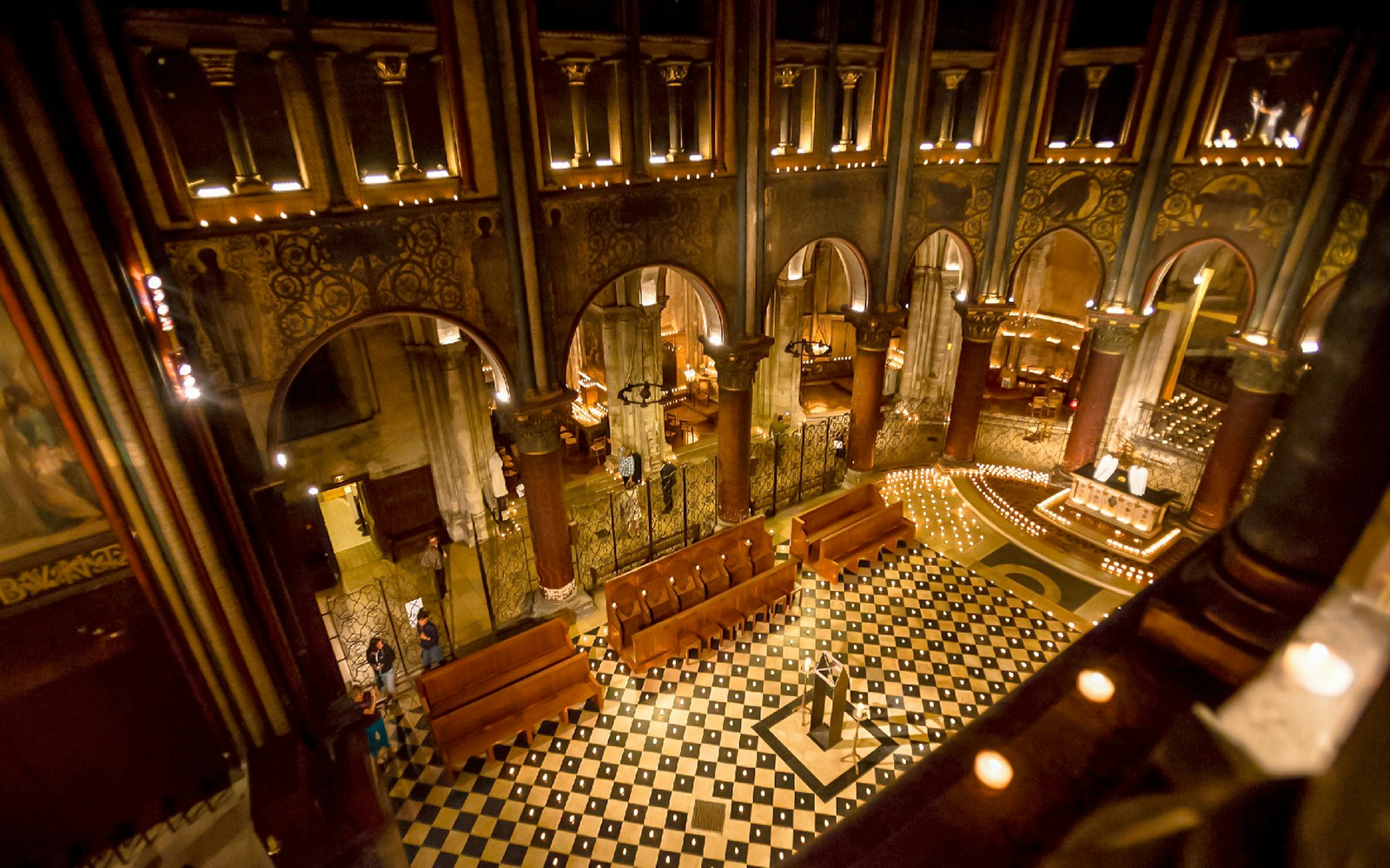Orchestra setup in St Germain des Prés Church, Paris, with lit candles and ornate architecture.