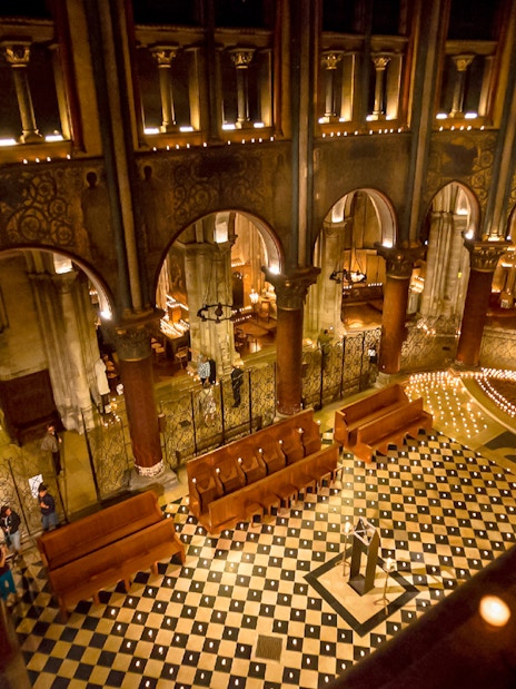 Orchestra setup in St Germain des Prés Church, Paris, with lit candles and ornate architecture.