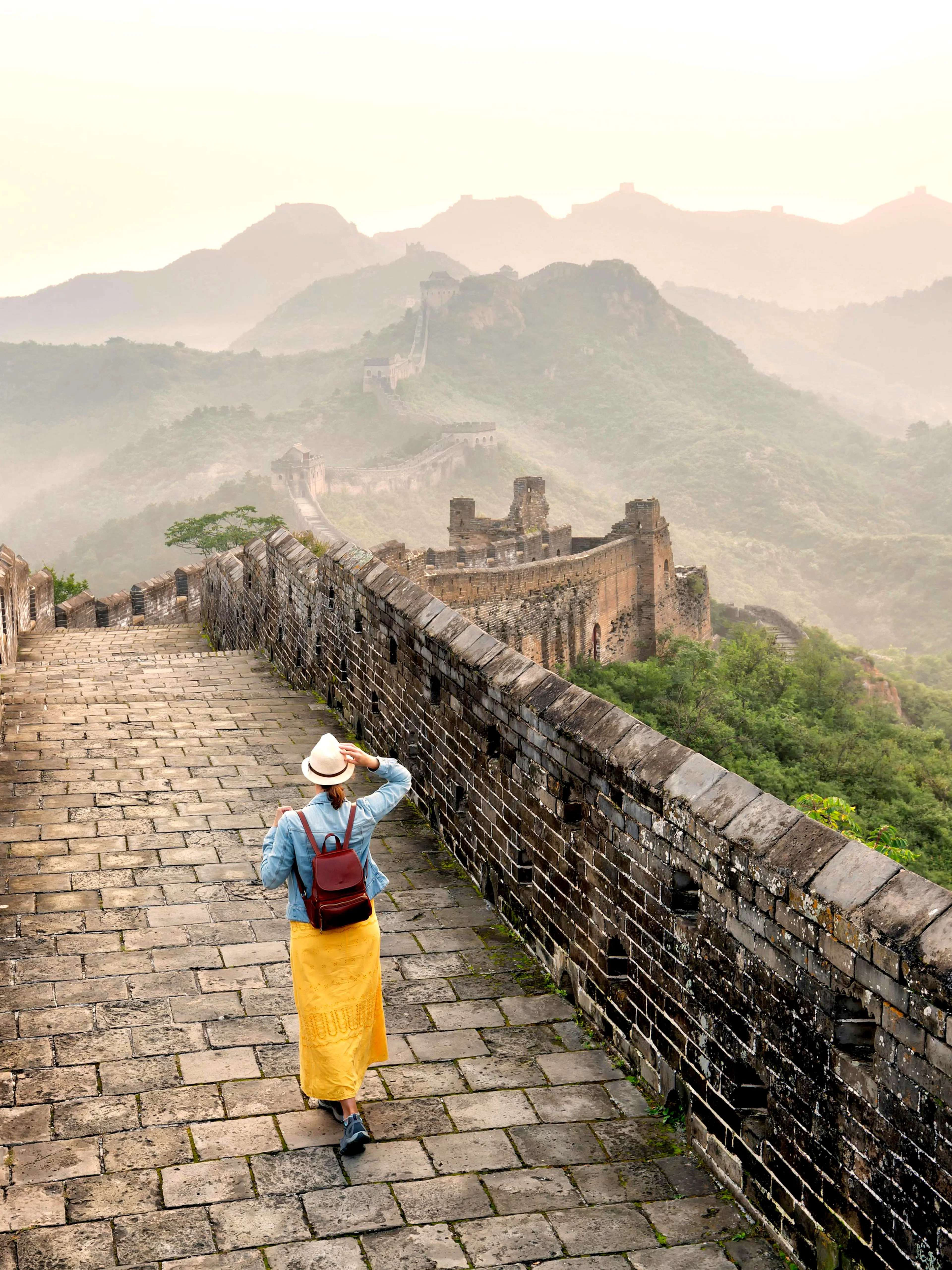Young tourist walking alone on Mutianyu section of the Great Wall of China.