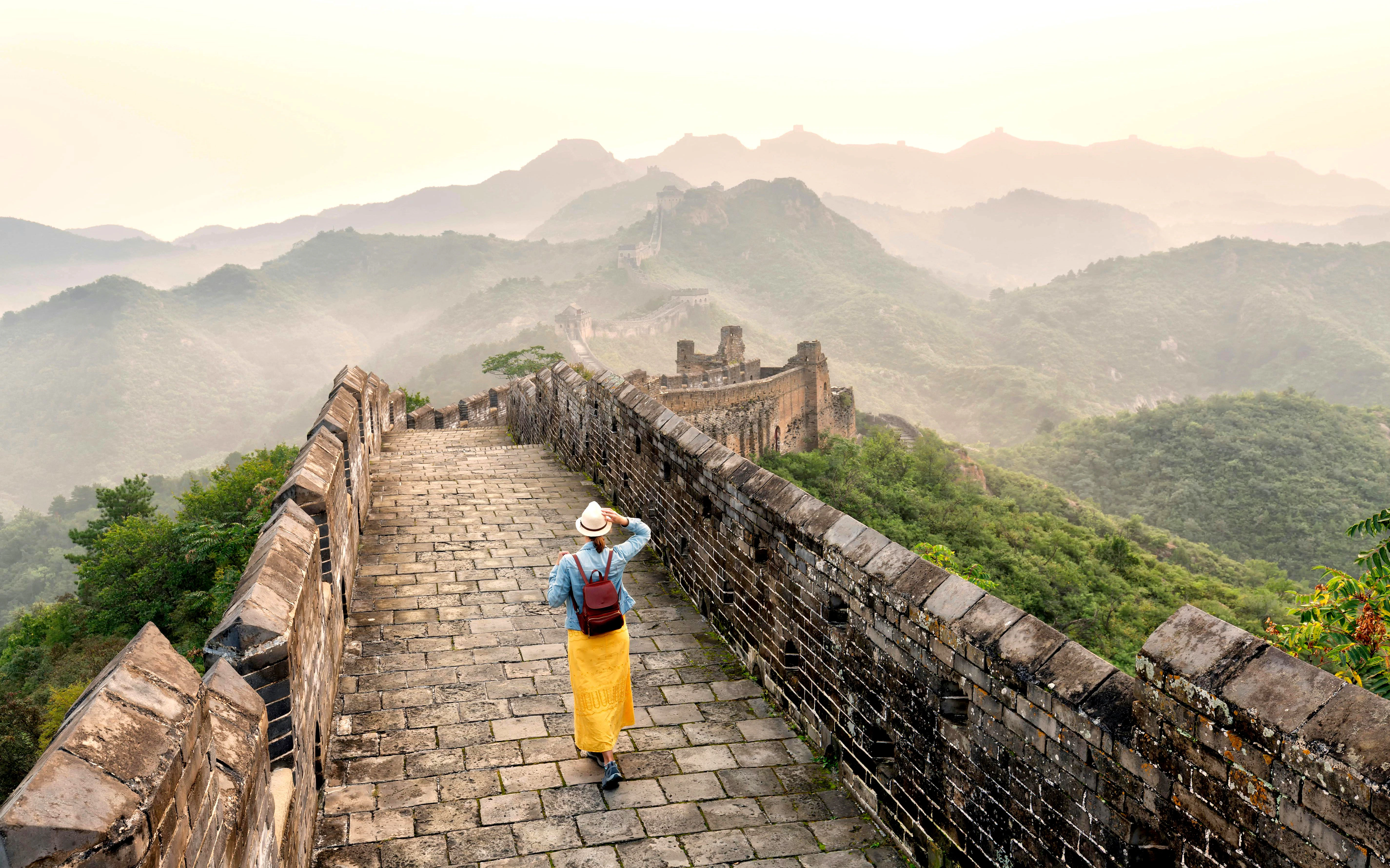 Young tourist walking alone on Mutianyu section of the Great Wall of China.