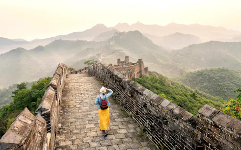 Young tourist walking alone on Mutianyu section of the Great Wall of China.
