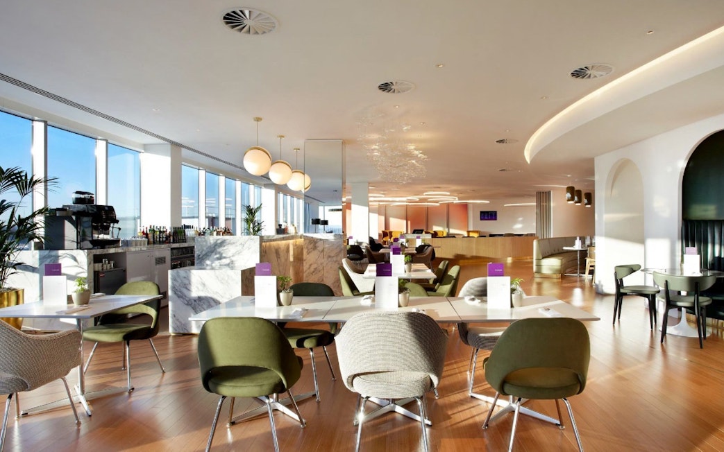 Plaza Premium Lounge seating area with tables and chairs, London Gatwick Airport North Terminal.
