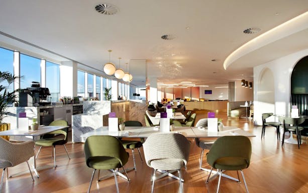 Plaza Premium Lounge seating area with tables and chairs, London Gatwick Airport North Terminal.