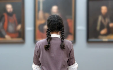 Visitor observing portraits at Prague National Museum exhibits.