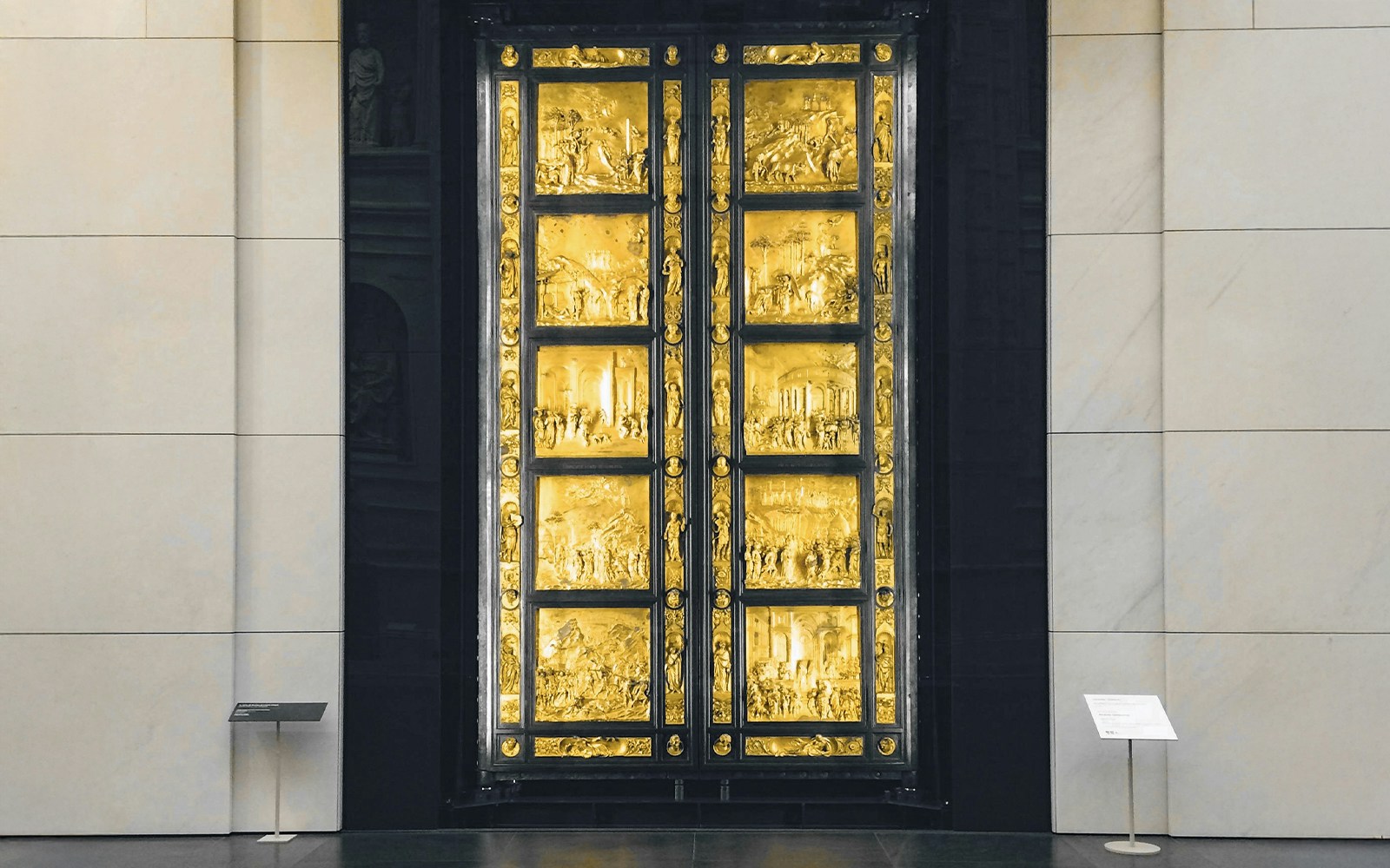 Bronze door with intricate panels at Opera del Duomo Museum, Florence.