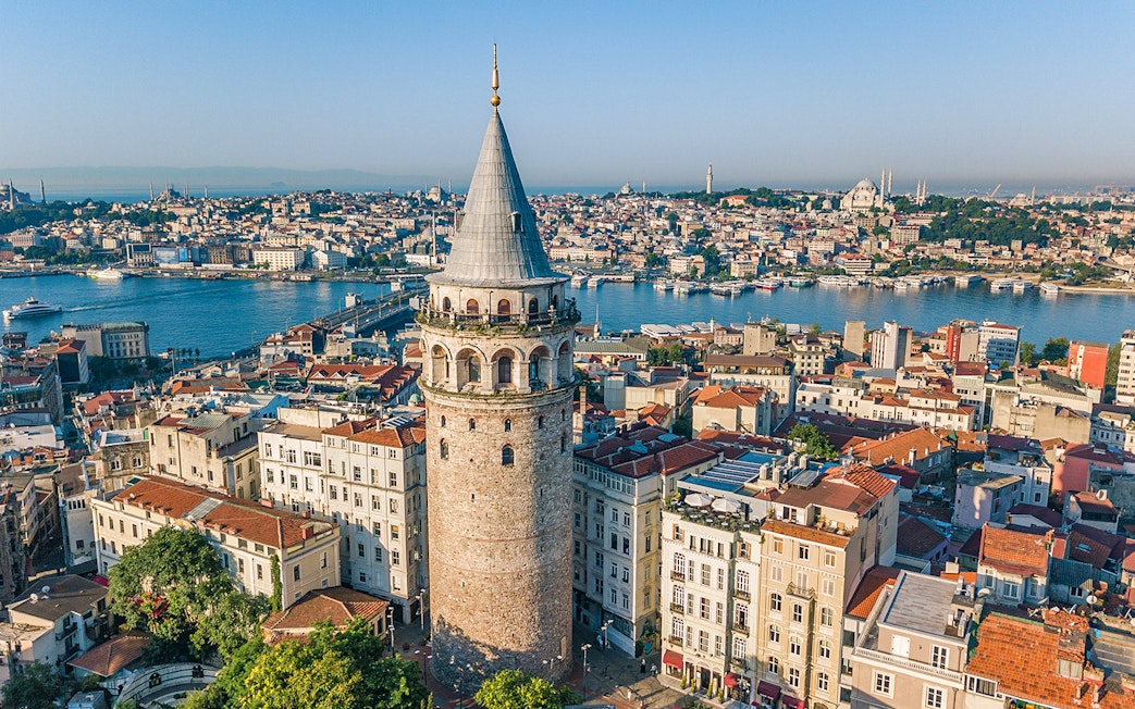 Galata Tower overlooking Istanbul cityscape and Bosphorus River.