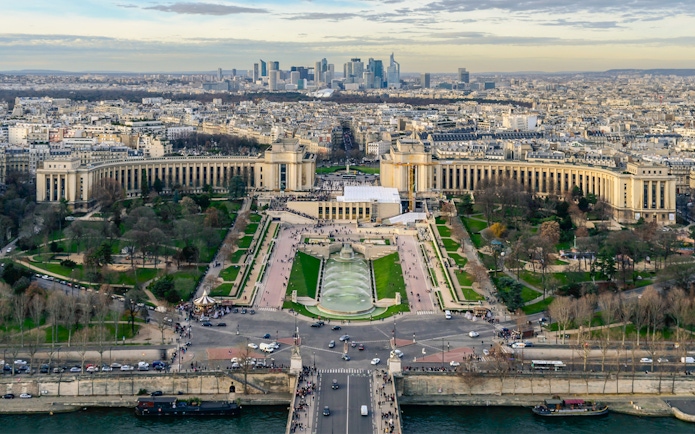 Panoramic view of Paris from Eiffel Tower Summit, featuring Trocadéro Gardens and cityscape.