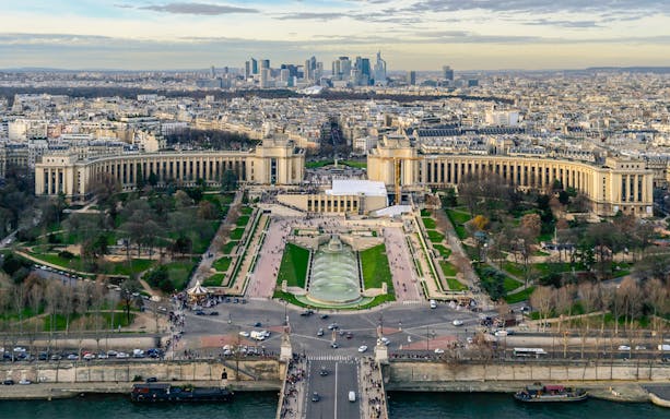 Panoramic view of Paris from Eiffel Tower Summit, featuring Trocadéro Gardens and cityscape.