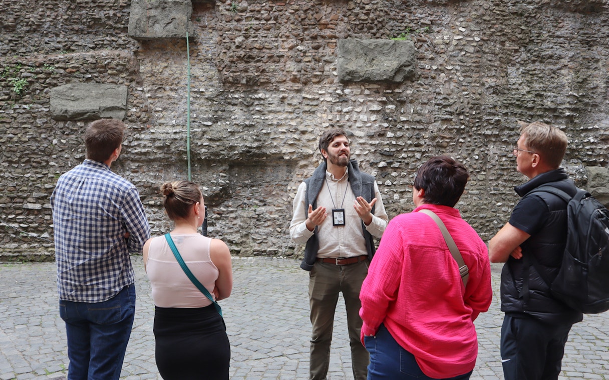 Guide explaining history to tourists at Castel Sant'Angelo, Rome.