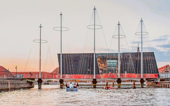 Circle Bridge over Copenhagen Harbor with cityscape backdrop.