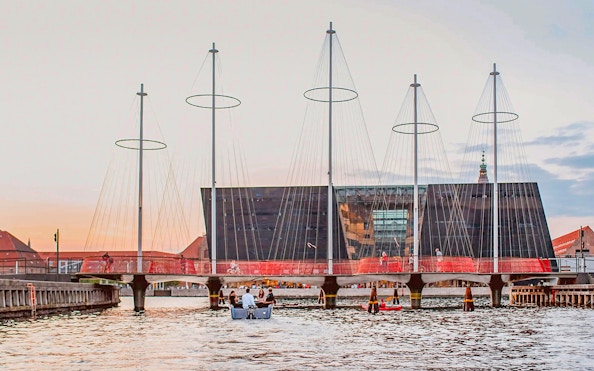 Circle Bridge over Copenhagen Harbor with cityscape backdrop.