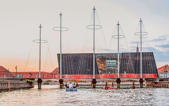 Circle Bridge over Copenhagen Harbor with cityscape backdrop.