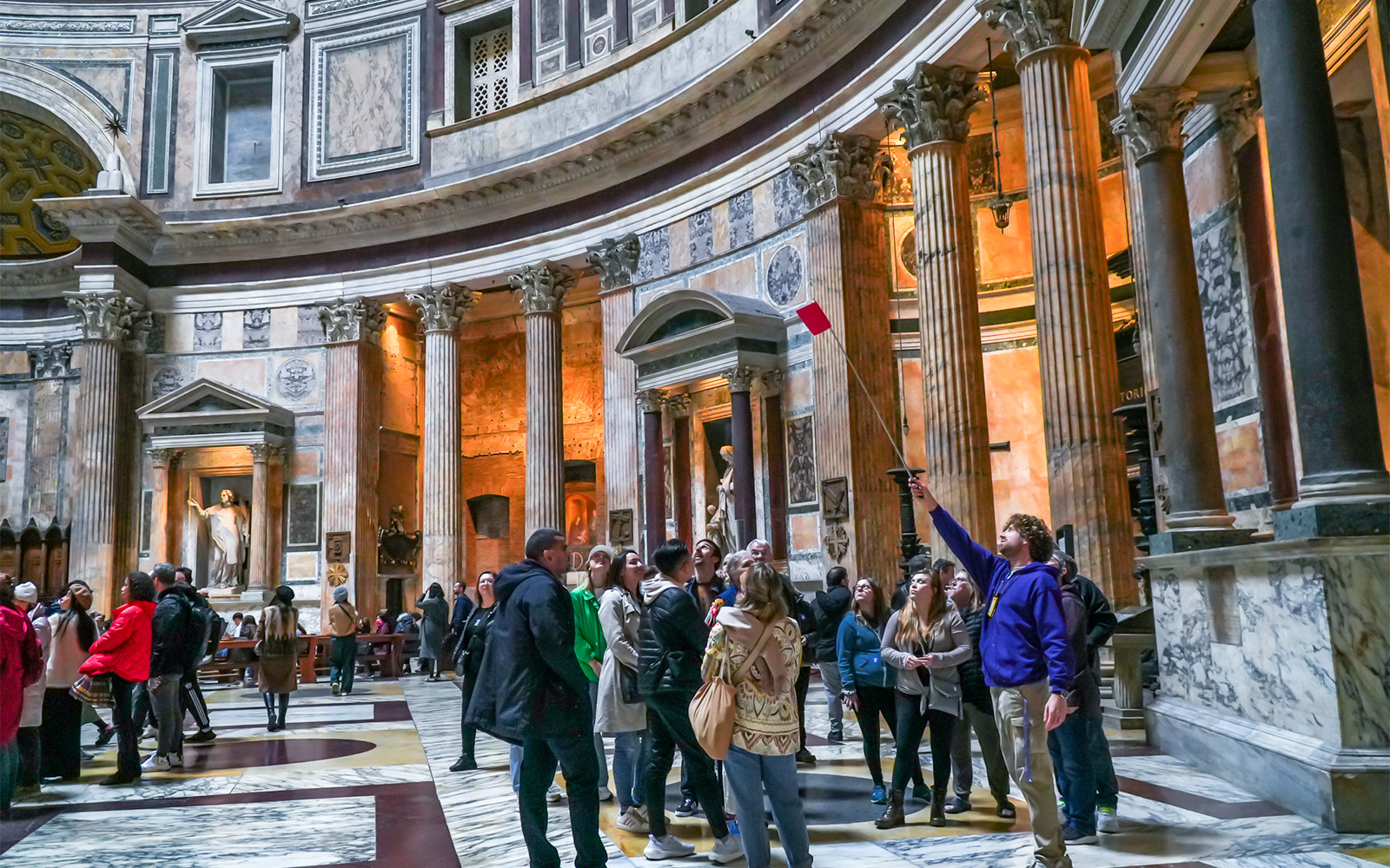 Tour guide with tourists inside the Roman Pantheon, Rome, Italy.
