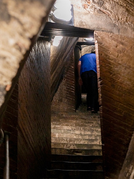 Inner stairs of Florence Cathedral dome with a person ascending.
