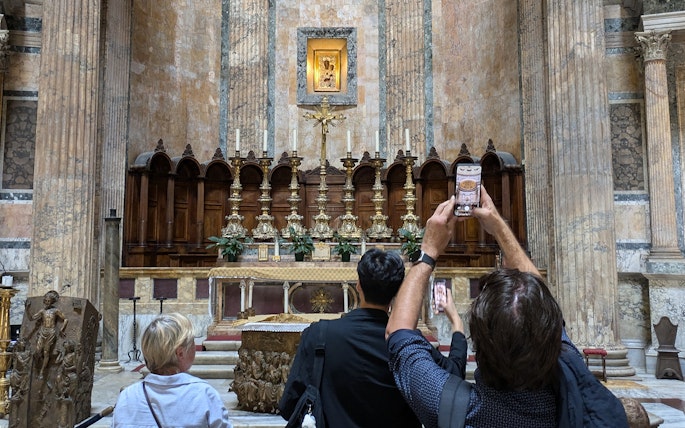 Visitors photographing the altar inside the Pantheon in Rome.