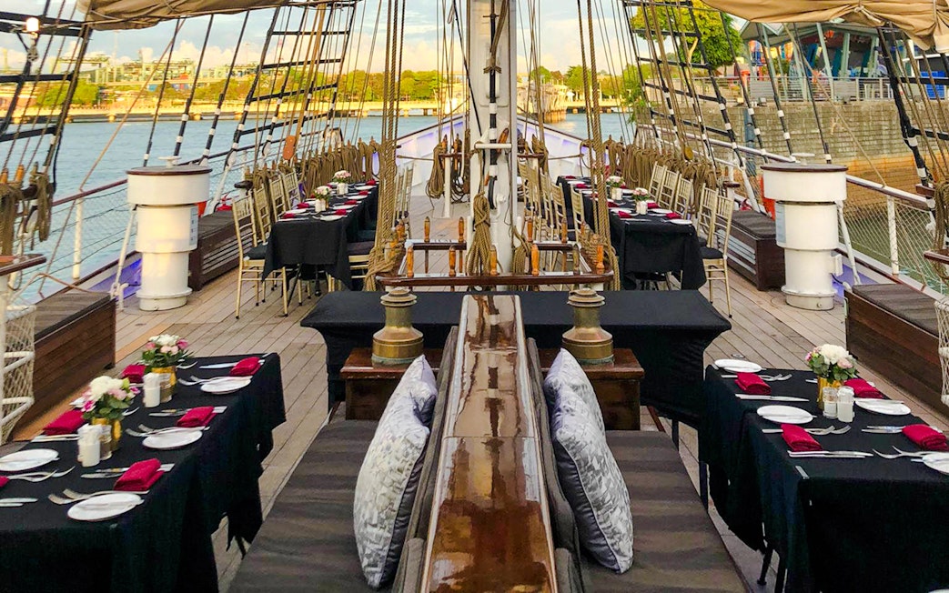 Dinner tables set on the deck of The Royal Albatross for a sunset cruise.