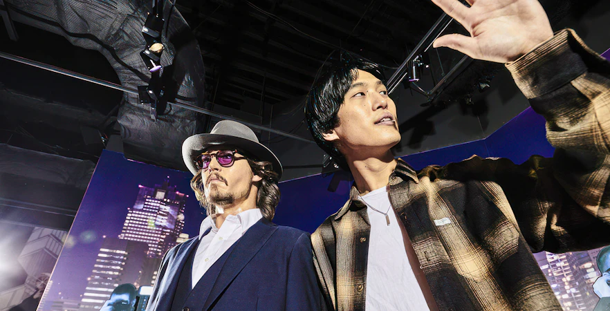 Wax figure exhibit at Madame Tussauds Tokyo with cityscape backdrop.