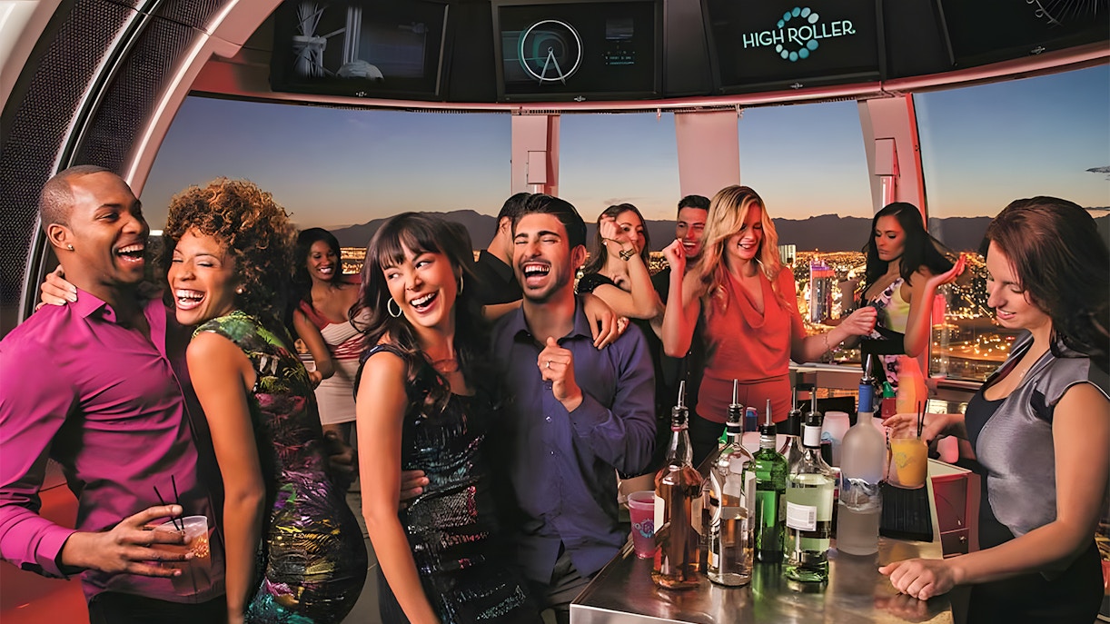 Guests celebrating at High Roller Observation Wheel in Las Vegas with city views.