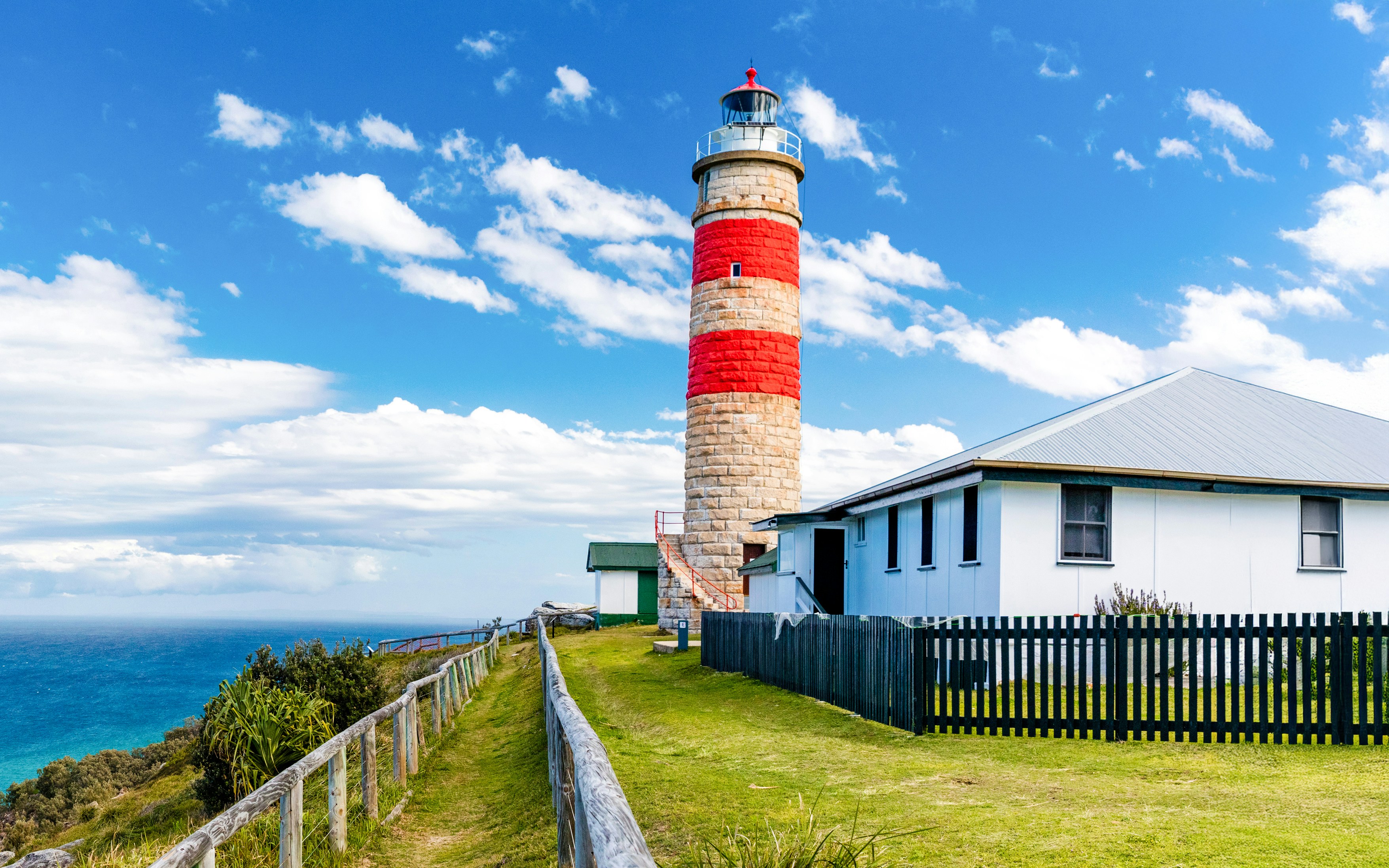 Lighthouse on Moreton Island with ocean view and adjacent building.