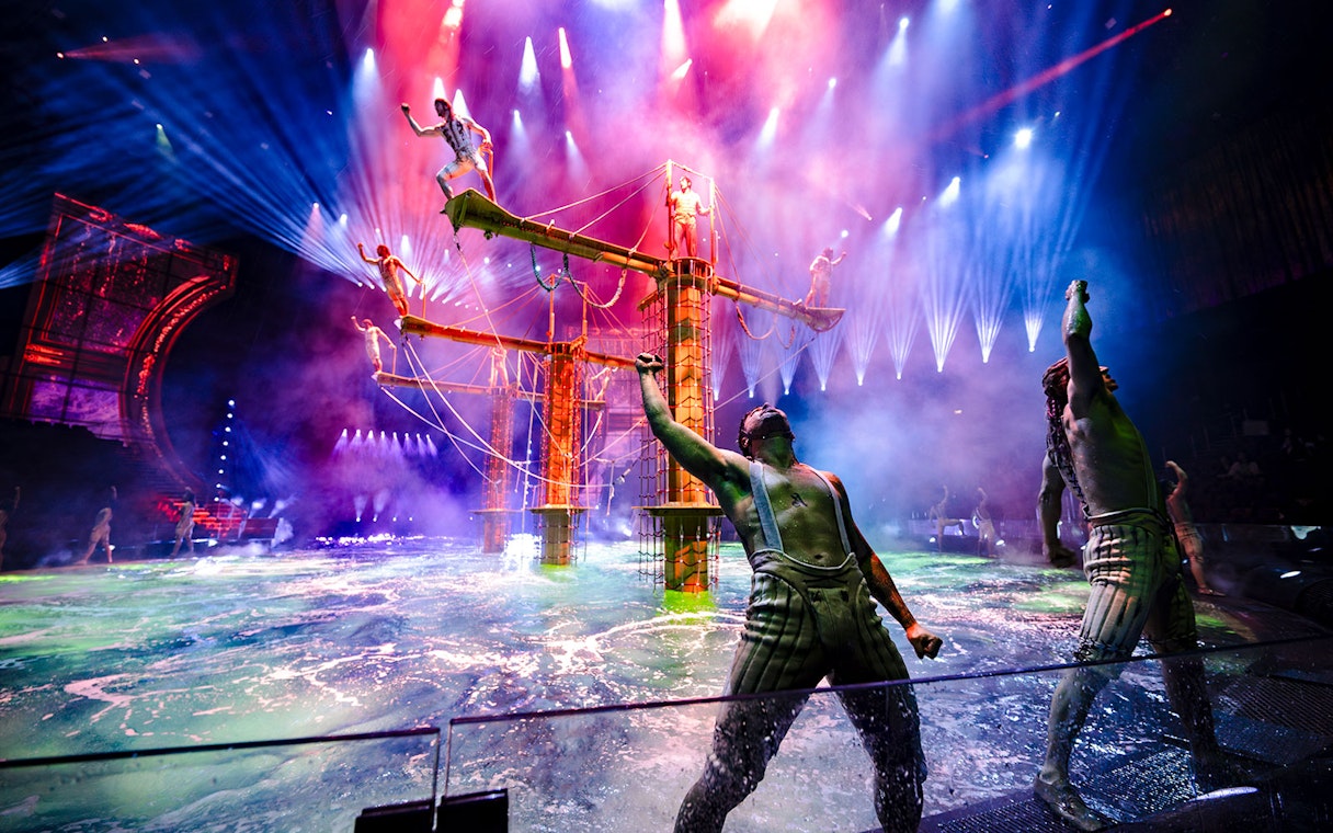 Acrobats performing on water stage during House of Dancing Water show.