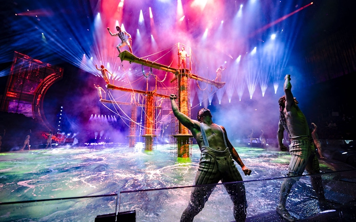 Acrobats performing on water stage during House of Dancing Water show.