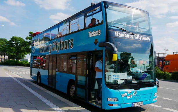 Hop-on hop-off bus for Hamburg City Tours parked on a street.