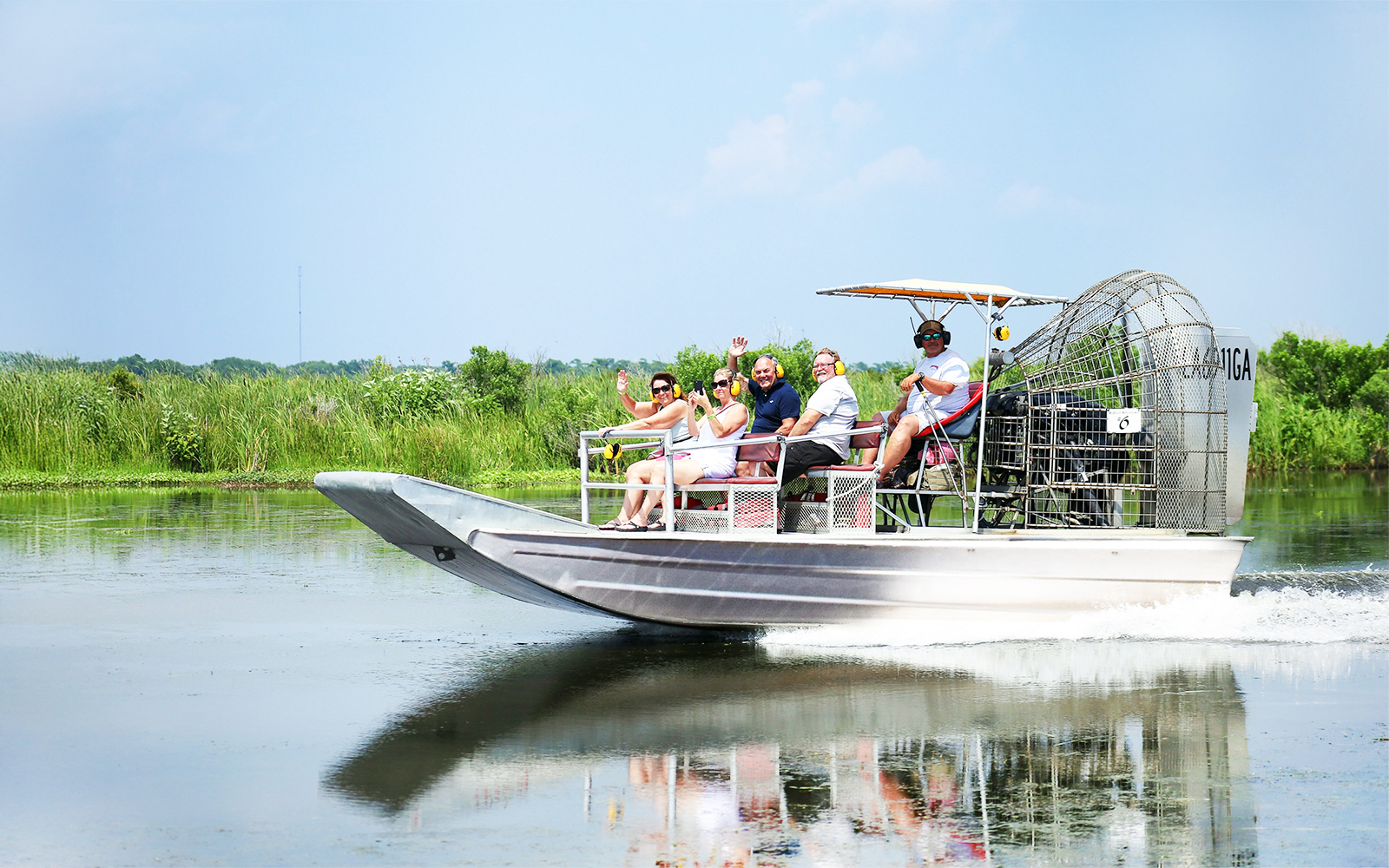 Airboat tour with people exploring a swamp in New Orleans.