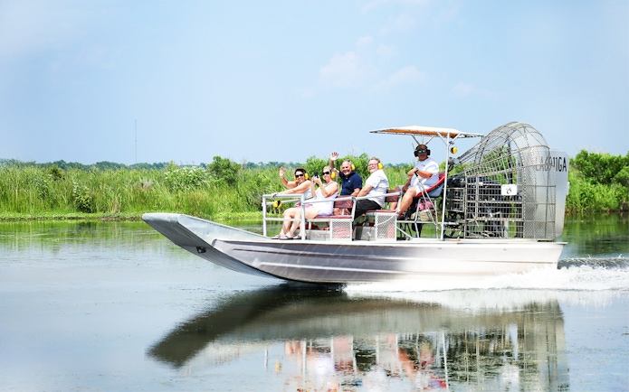 Airboat tour with people exploring a swamp in New Orleans.