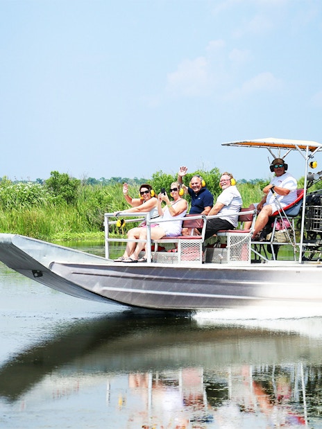Airboat tour with people exploring a swamp in New Orleans.