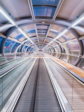 Futuristic walkway at Orly Airport, Paris, with glass and metal design.