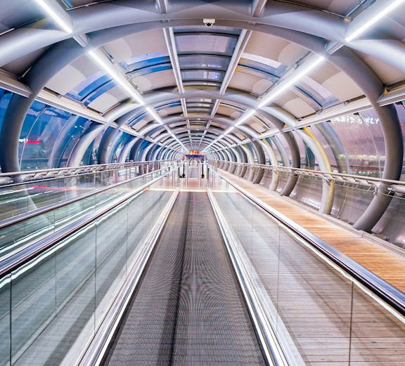 Futuristic walkway at Orly Airport, Paris, with glass and metal design.