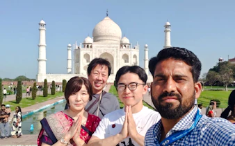 Visitors posing in front of the Taj Mahal during a fast-track entry tour in Agra.