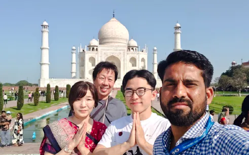 Visitors posing in front of the Taj Mahal during a fast-track entry tour in Agra.