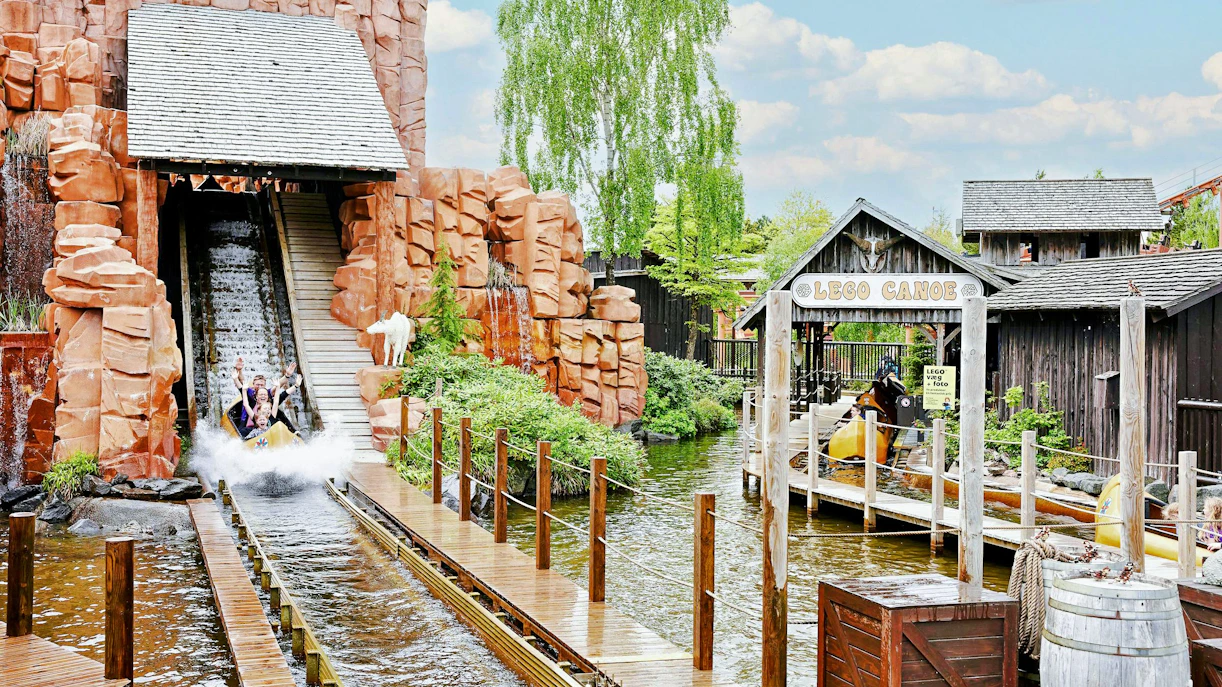 Visitors enjoying a water ride at LEGOLAND® Billund with LEGO Canoe sign.