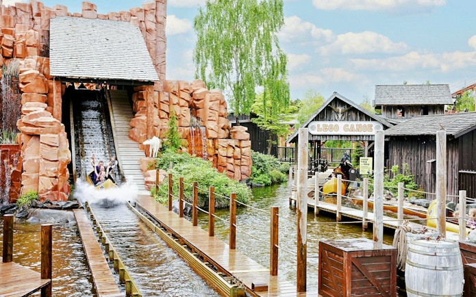 Visitors enjoying a water ride at LEGOLAND® Billund with LEGO Canoe sign.