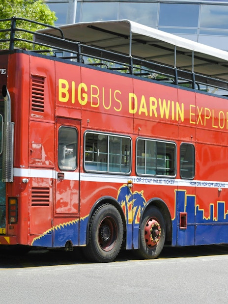Big Bus Darwin Explorer parked near Crocosaurus Cove, promoting hop on hop off tours.