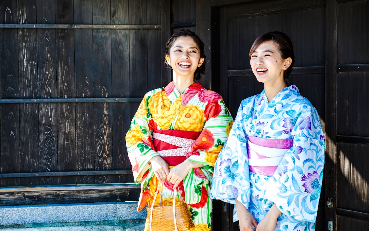 Women in colorful kimonos smiling in Tokyo, Japan.