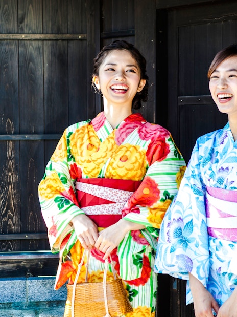 Women in colorful kimonos smiling in Tokyo, Japan.