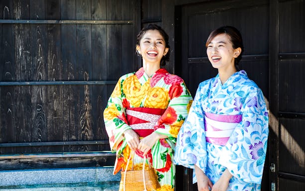 Women in colorful kimonos smiling in Tokyo, Japan.