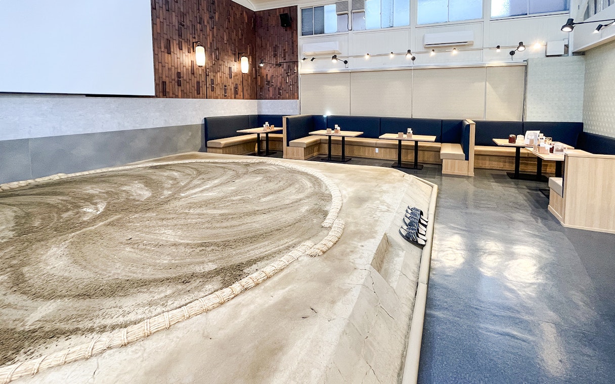 Sumo wrestling arena with seating area in a modern venue.